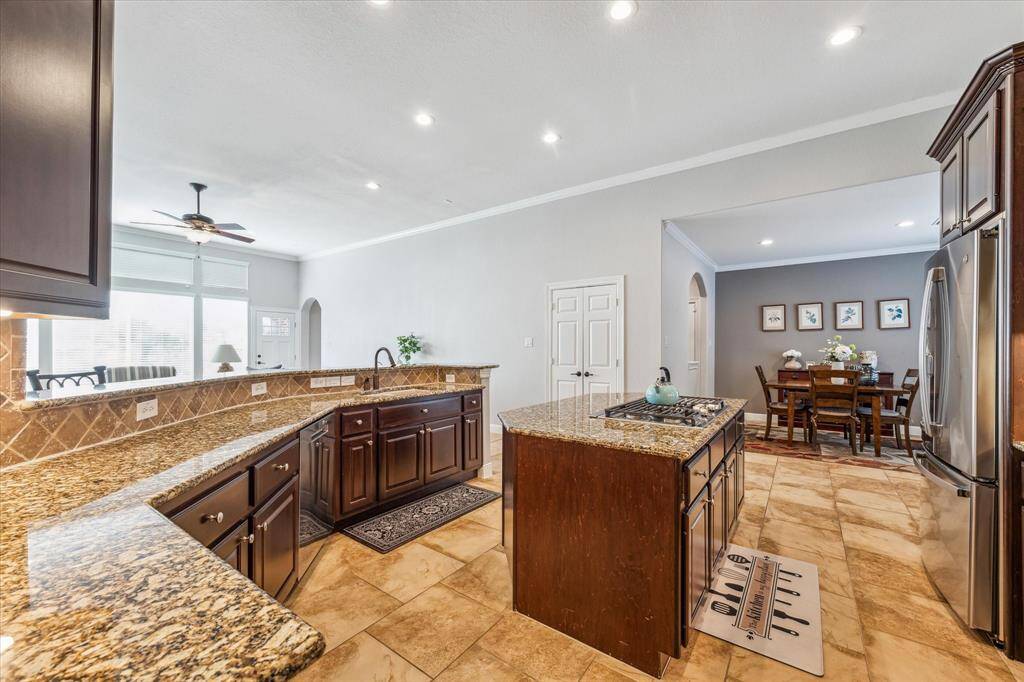 Stainless steel appliances. The open layout flows into a dining area and living space with large windows, offering plenty of natural light.