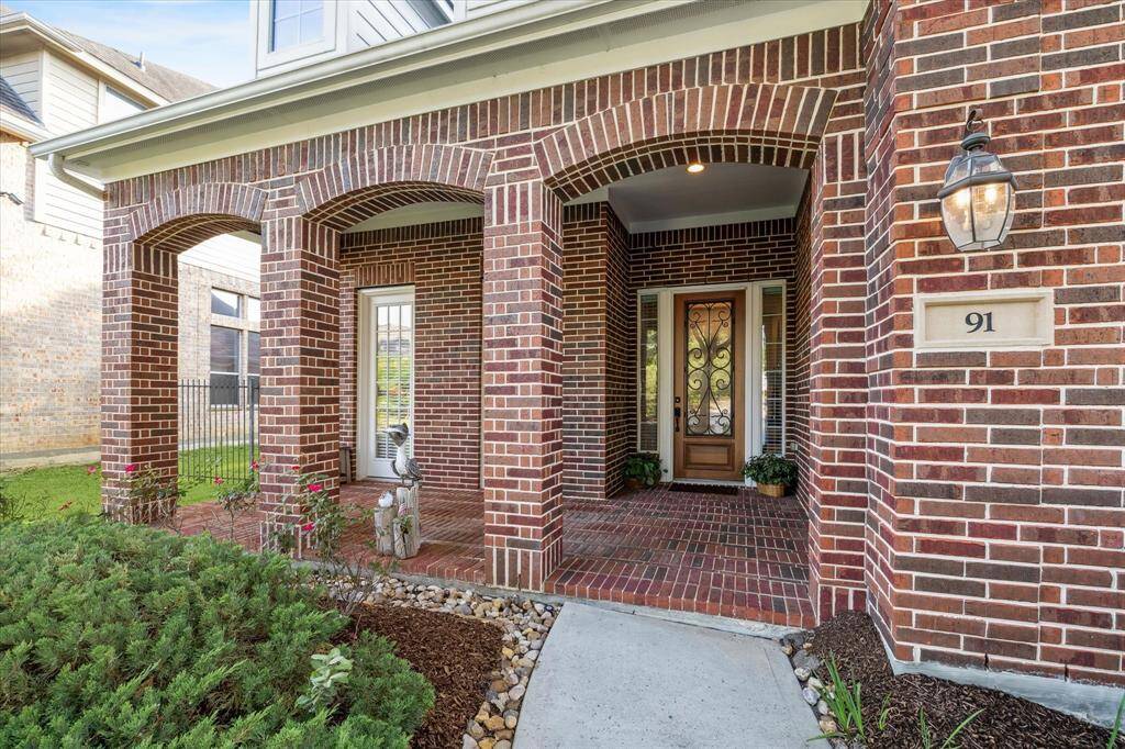 A covered front porch and arched entryways, a stylish front door with decorative glass add to its curb appeal.