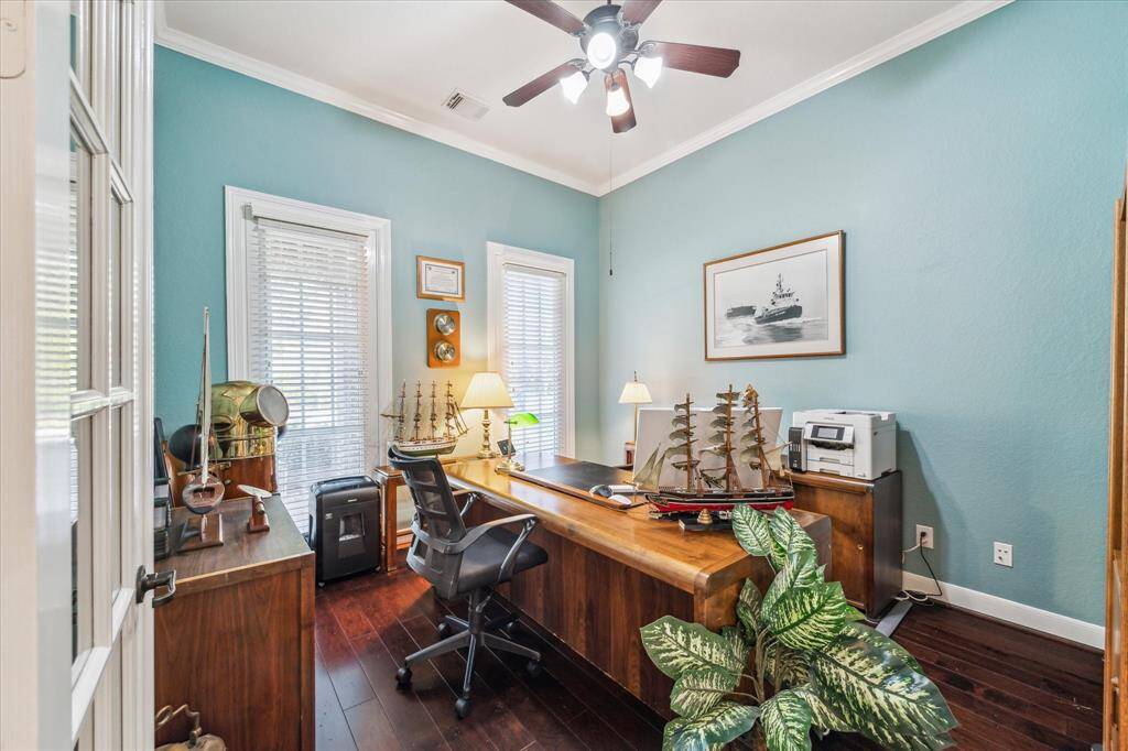 This home office features a cozy, spacious well-lit space.
