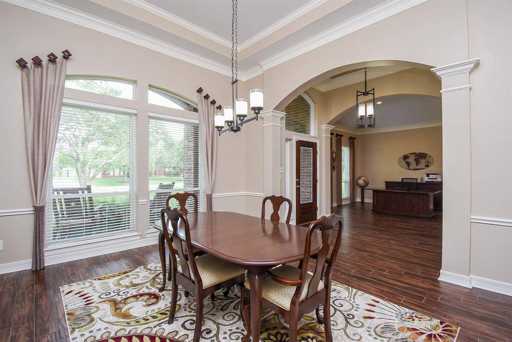 A touch of refined elegance with elevated ceiling detail in this large dining area.  Updated chandelier, freshly painted walls and gorgeous wood tile flooring.