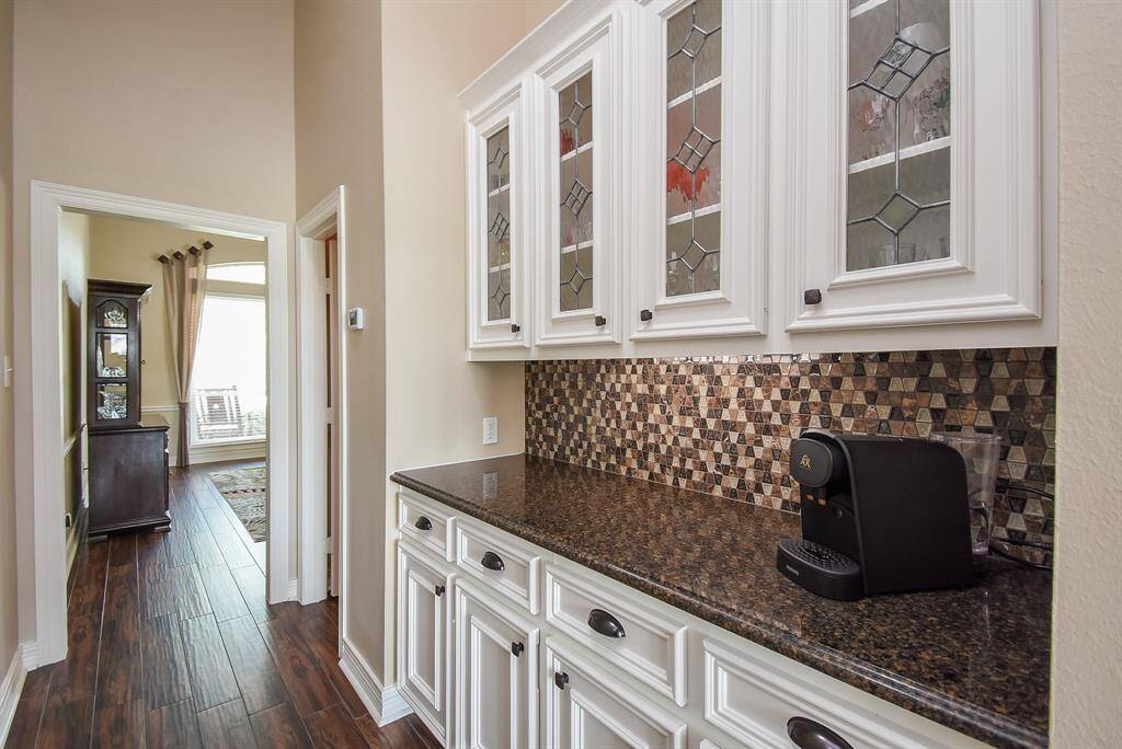 This butlers pantry has been completely updated ... refinished & painted cabinets with beveled glass faces, under counter lighting, new counter top, exquisite back-splash tile, new hardware.