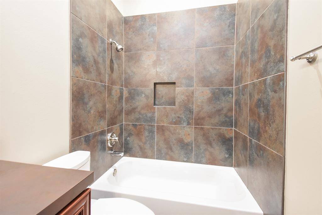This secondary bath has new expanded tub and new toilet.  Beautiful rustic tile and hardware.