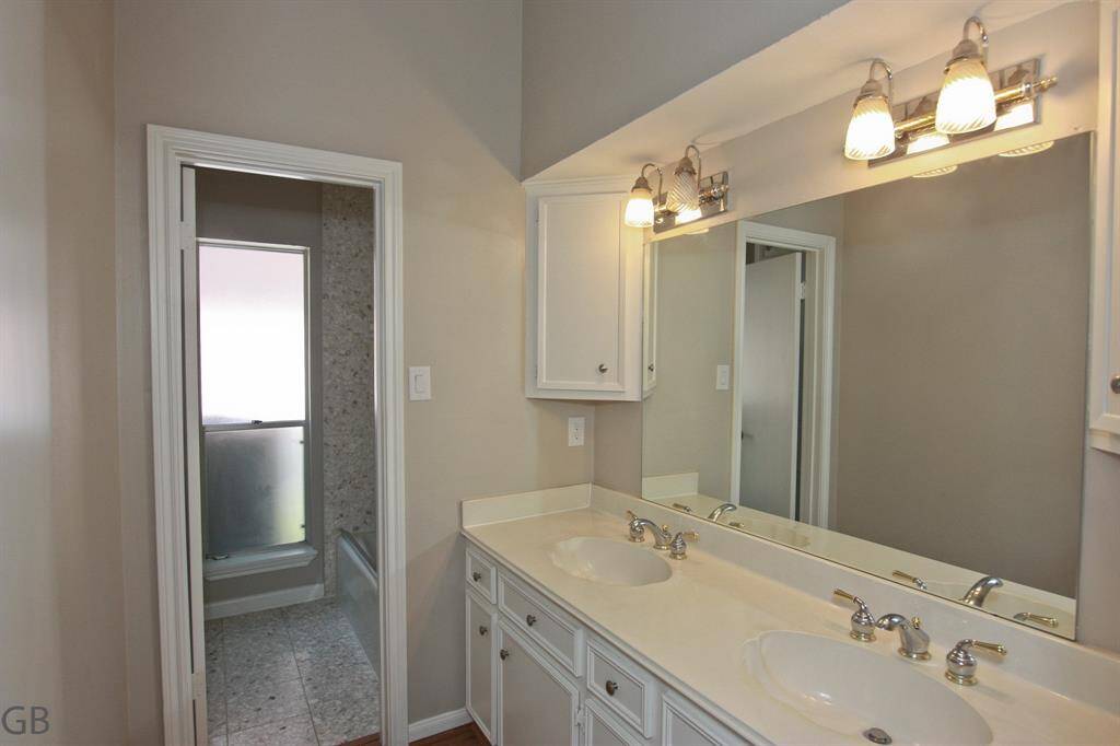 Secondary bath with double sinks, wet area through that door.