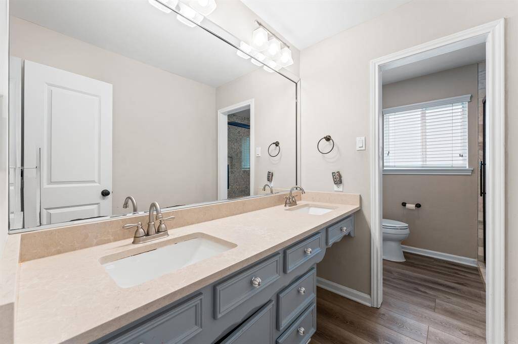 Primary bathroom with dual-sink vanity with a modern, lighting.