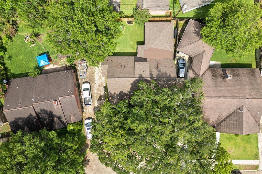 Aerial view! House is surrounded by mature trees, providing ample shade and privacy.