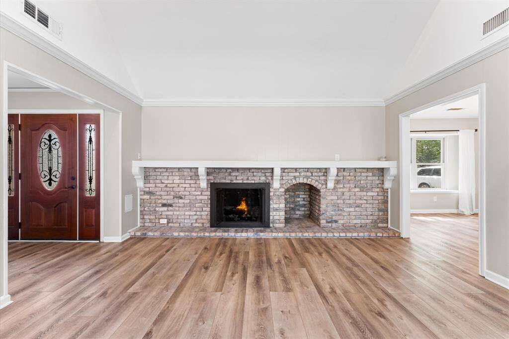 The wood burning brick fireplace is the focal point of the living/family room. Complemented by elegant luxury vinyl floors and ample natural light.