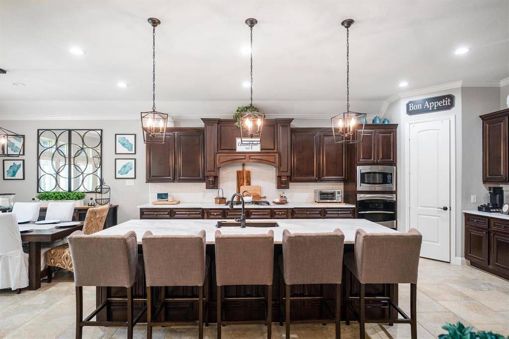Spacious kitchen with expansive countertops seating 5 bar stools, enhanced by upgraded lower cabinets featuring convenient drawers for optimized storage.