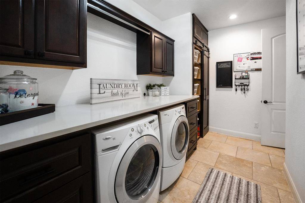 Fully upgraded spacious laundry area with ample countertop and abundant storage.
