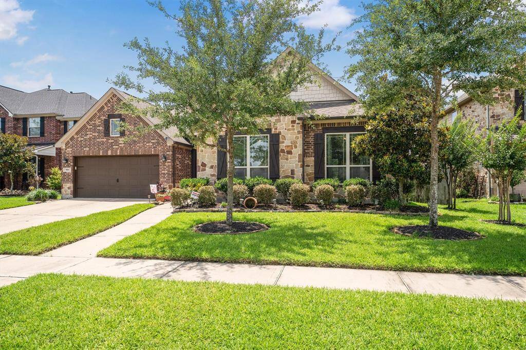 Stunning home enhanced by lush, beautifully maintained landscaping.
