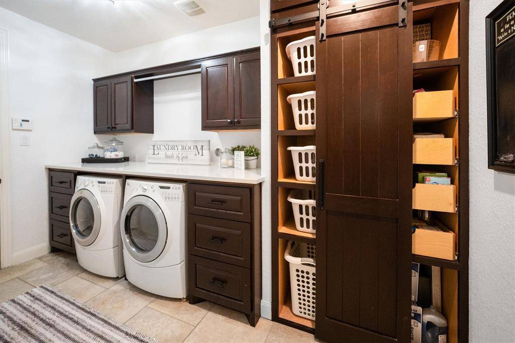 Stylish laundry room with a upgraded sliding door, featuring convenient basket storage and ample drawer space.