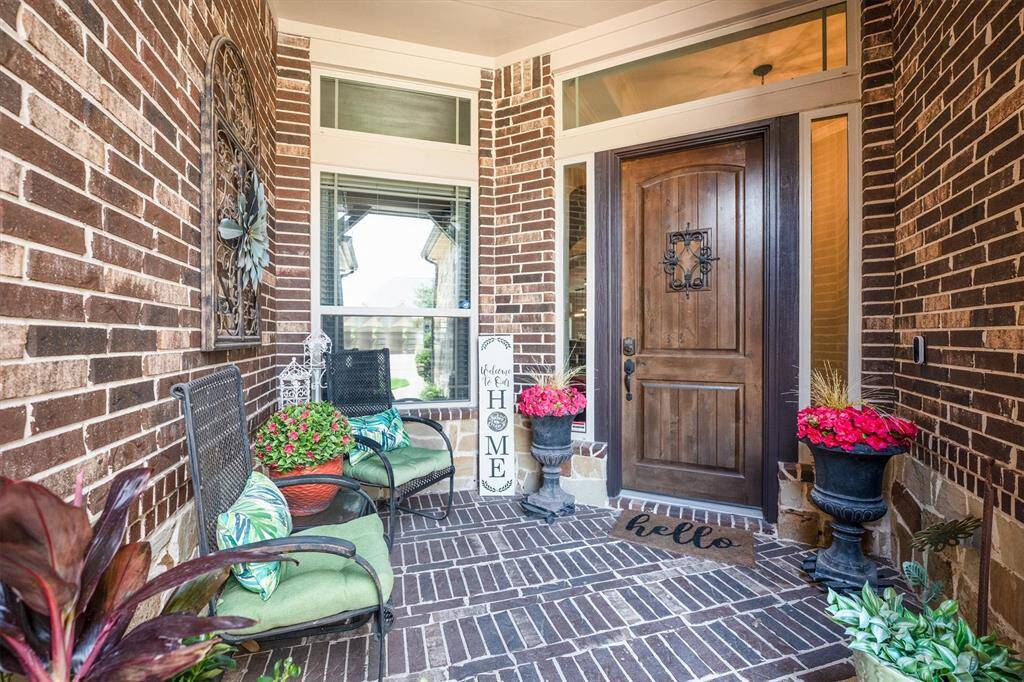 Inviting front entry with an elegant wood door and spacious seating area.