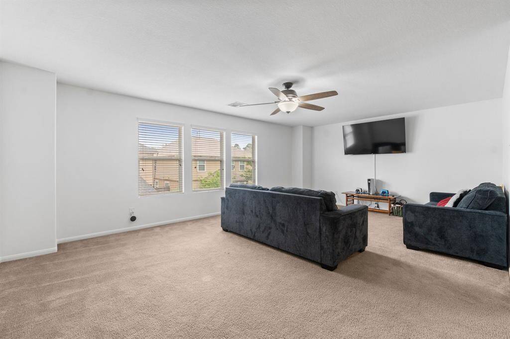 Spacious game room, large windows for natural light, and a ceiling fan Ideal for relaxation and entertainment.