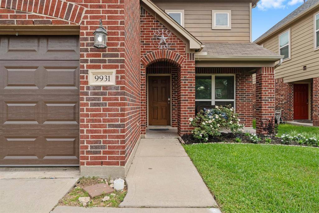 Charming two-story brick home with a welcoming front entrance, neat landscaping, and a double-car garage. Perfectly maintained exterior with a cozy porch area.