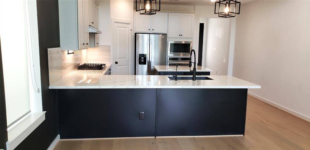 Sleek quartz countertops paired with elegant pendant lighting add a touch of sophistication to the gourmet kitchen, making it both stylish and functional.