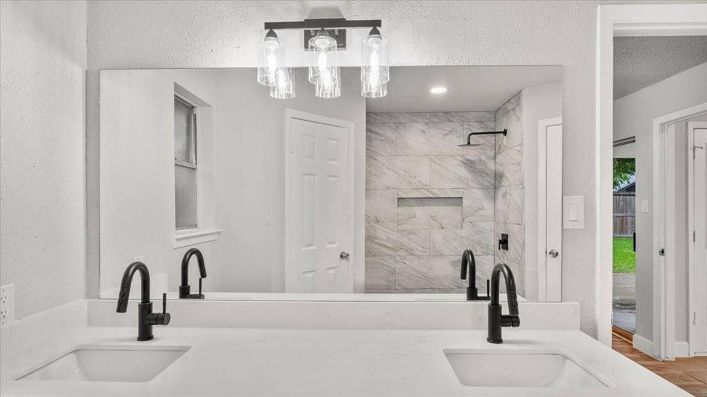 Primary bathroom stand up shower with "His" and "Hers" closets.