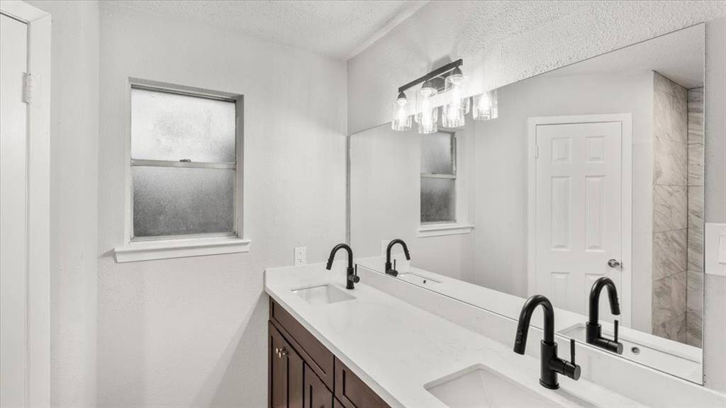 Primary bathroom stand up shower with "His" and "Hers" closets.