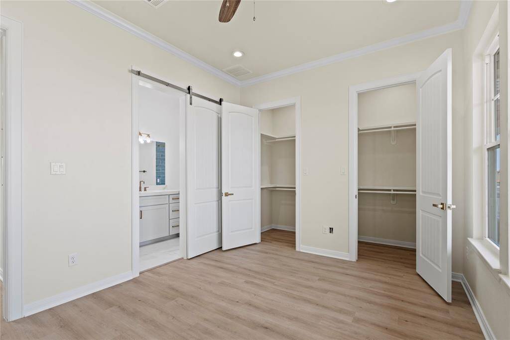 PRIMARY BEDROOM WITH HIS AND HER CLOSETS.