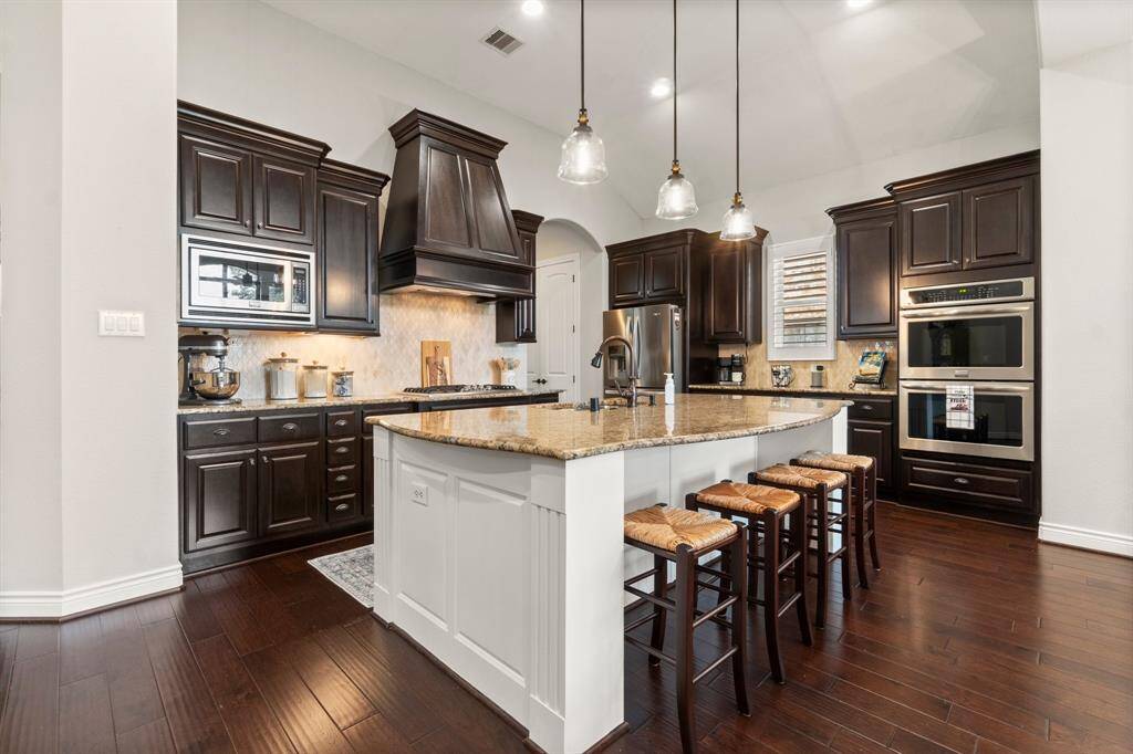 Kitchen features double ovens with amazing island open to living room.