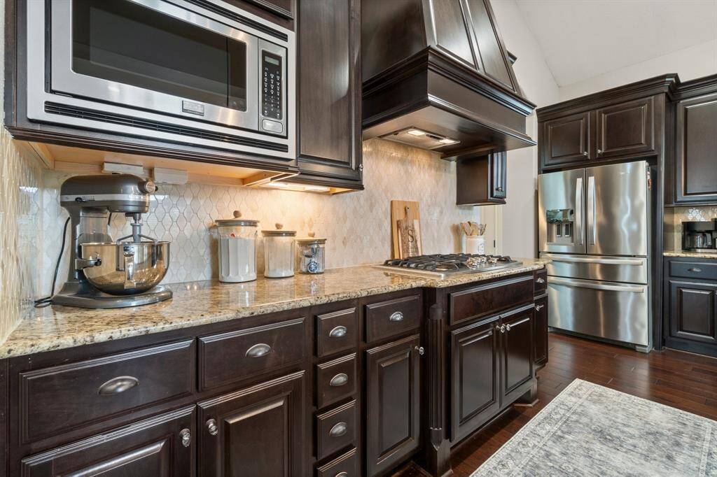 The kitchen boasts stainless steel appliances, a large island, and generous cabinetry.