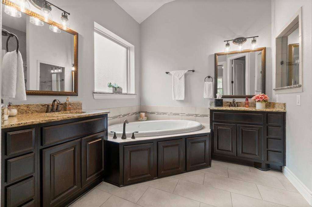 The en-suite bath features a soaking tub, oversized shower, dual vanities, and a large walk-in closet.