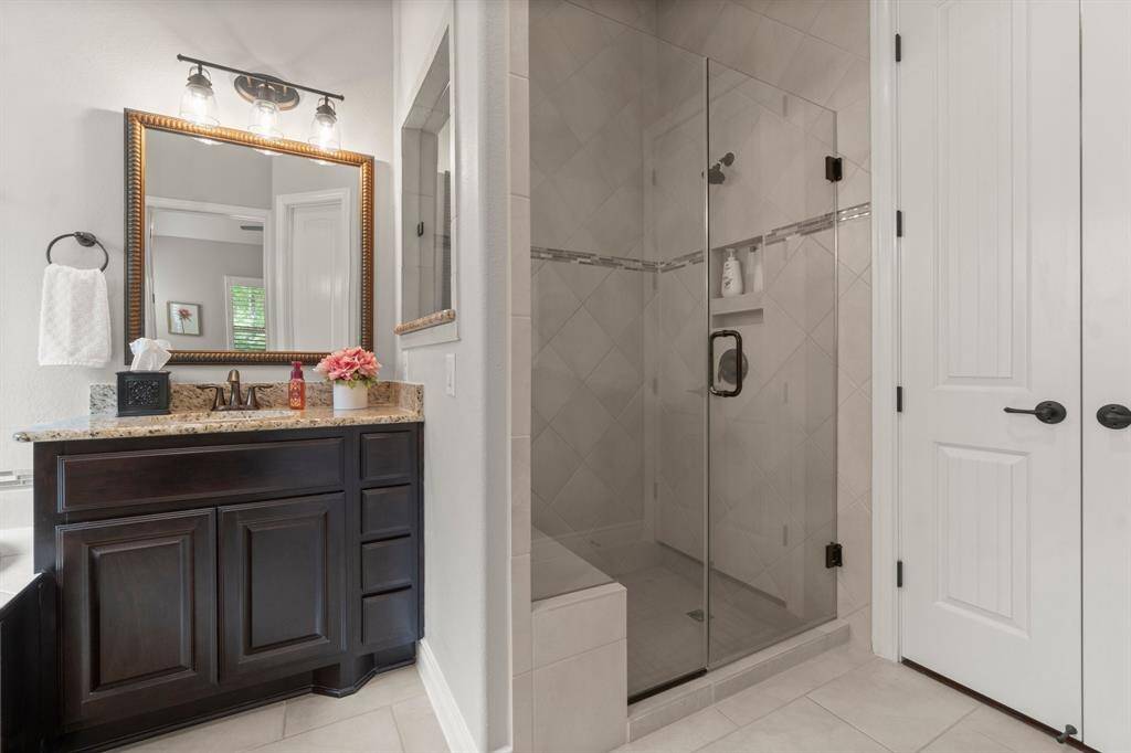 Tile in spacious shower goes up to ceiling.