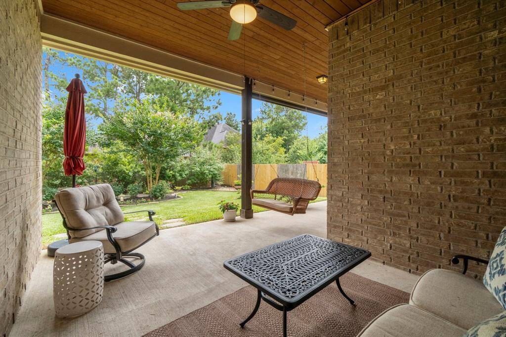 Enjoy the covered patio with a stained tongue-and-groove ceiling, surrounded by lush landscaping.