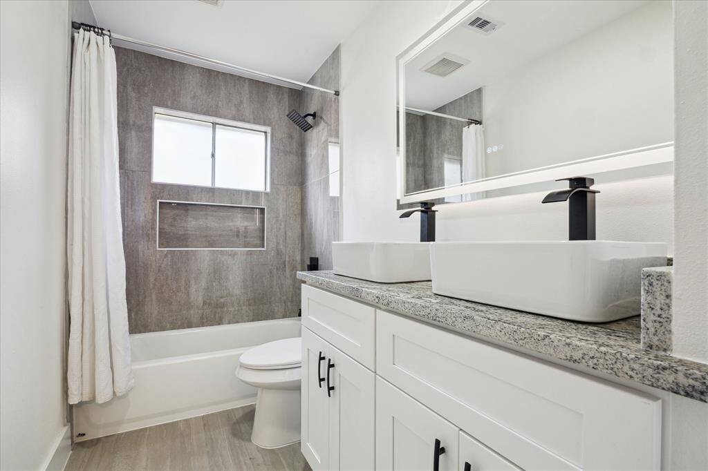 Guest bath includes Tub/shower combo, rainfall shower head, double sinks, and matching black and white granite countertops
