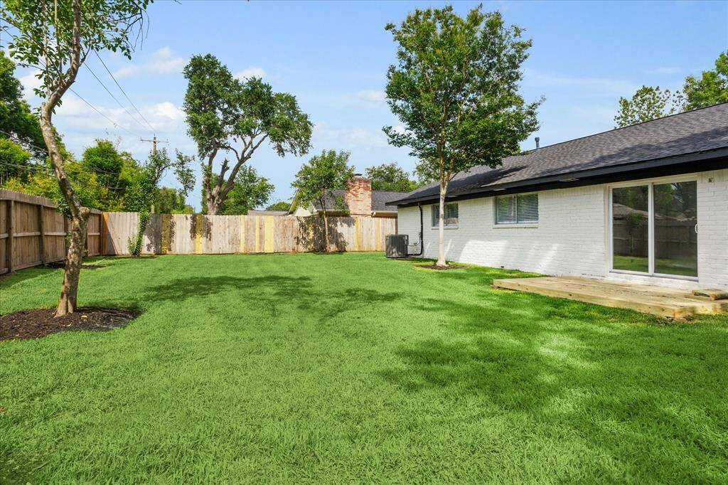 Expansive fenced backyard with a plywood deck—perfect for relaxing or entertaining