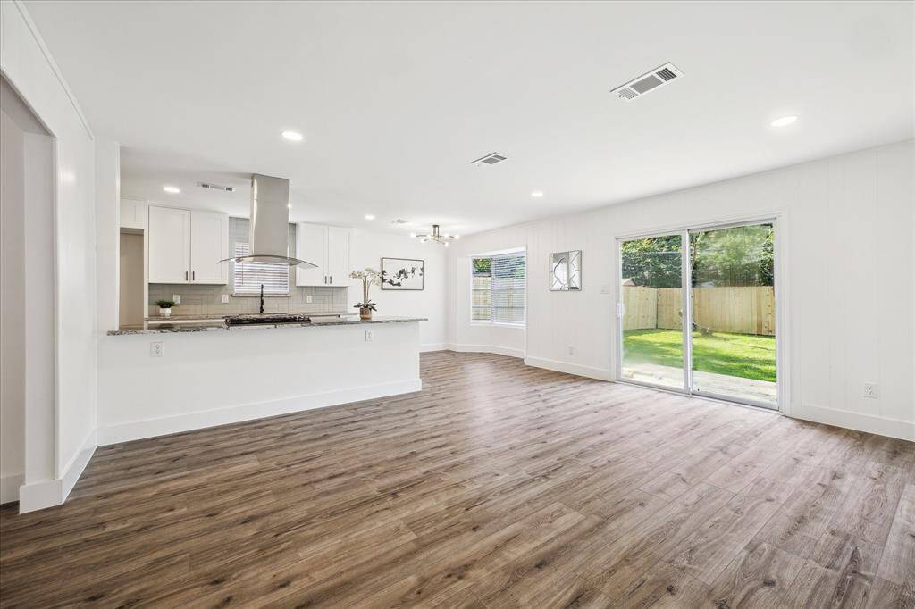 Fully updated kitchen with new stainless steel appliances, gas range, granite countertops, pull-down faucet, sleek new cabinetry, and a stylish tile backsplash.