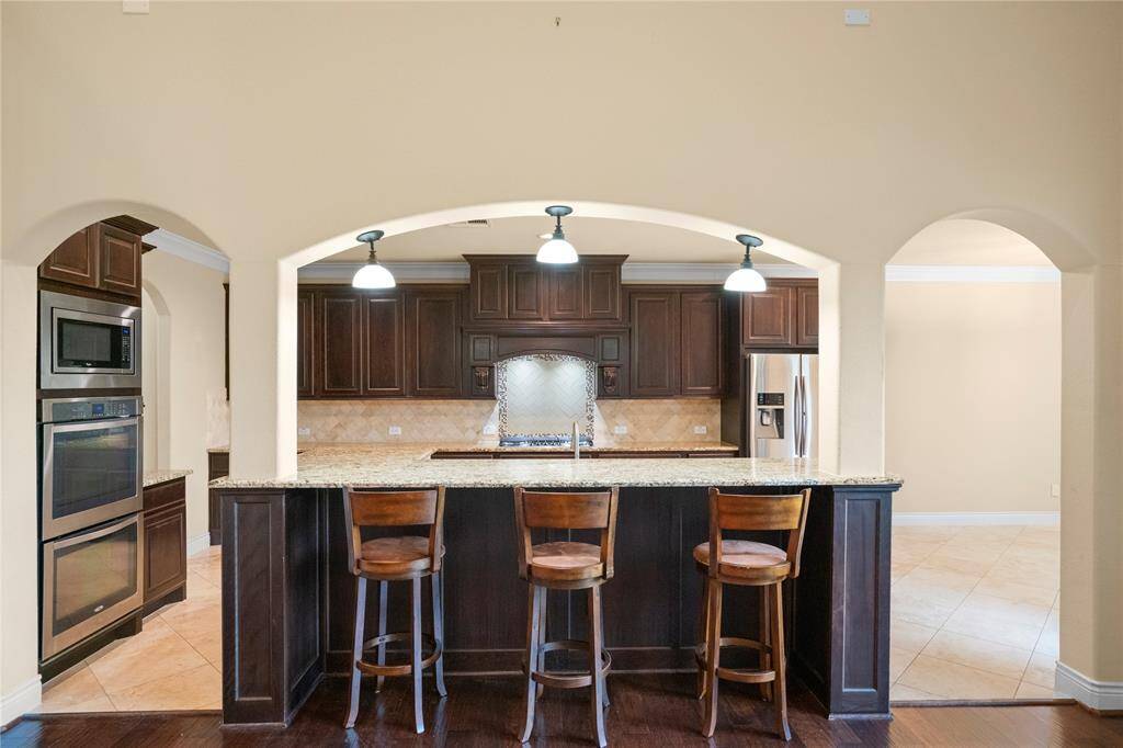 Stunning pendant kitchen bar lighting and arched walkways add to the beauty of the home.