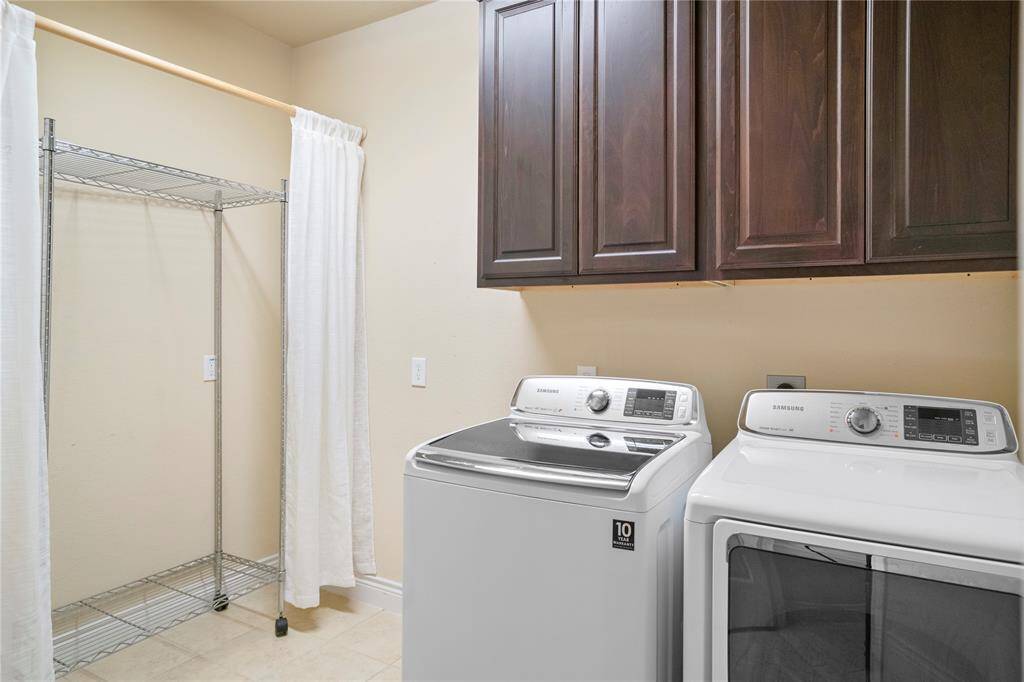 Huge downstairs laundry room tucked back towards 3 car garage entry and downst