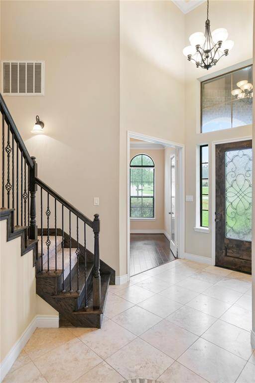 The foyer opens right up to a dramatic wrought iron staircase.