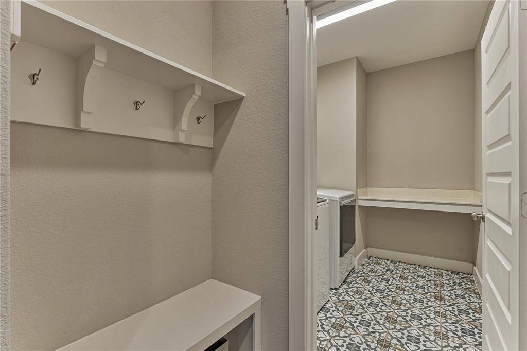 Downstairs mud room & utility room with upgraded designer tile flooring and additional shelving in utility room