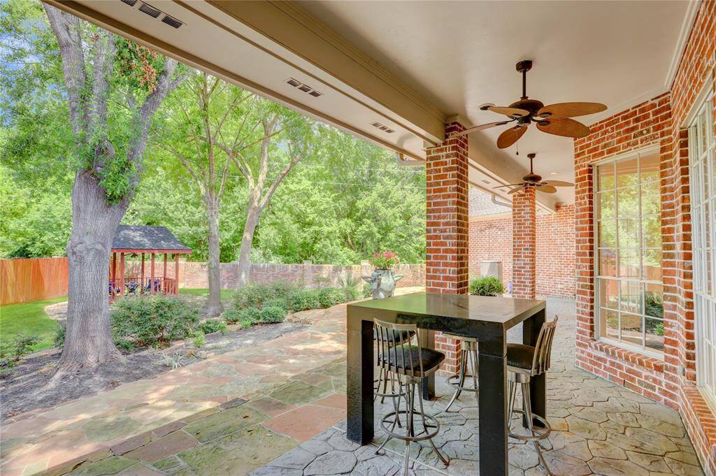 Long covered back patio with ceiling fans.
