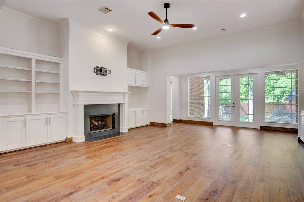 Living room has built-in cabinets and gas fireplace.