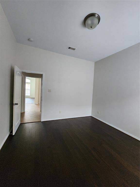 Primary Bedroom with high ceilings and wood floors