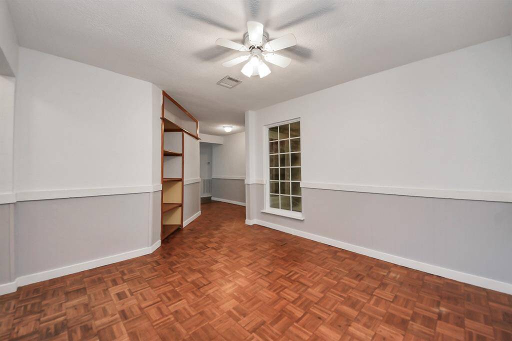 To the left of the entryway is a bonus space with ceiling fan overhead, chair rail molding along the walls, and a window that looks out toward the side of the home. Can be used as a formal dining area, office space, playroom, etc!