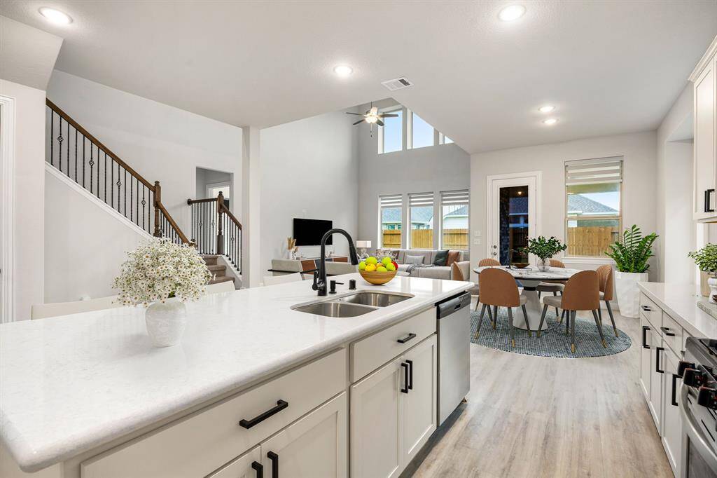The open concept living room and kitchen makes for a great way to keep the party going and never miss a beat! Gather the family together in good conversation while preparing a fabulous meal in this breathtaking kitchen! Featuring high ceilings, bright cabinets, Quartz countertops, SS appliances, modern tile backsplash, recessed lighting and kitchen island with a convenient breakfast bar!