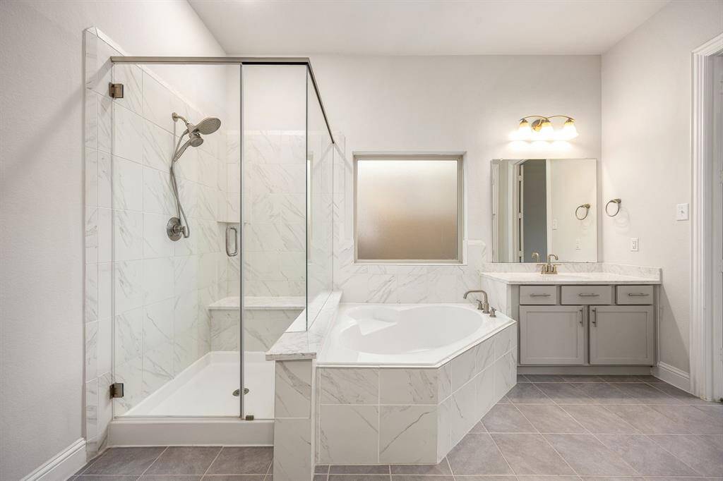 This extra perspective of the primary bath highlights the spacious walk-in shower adorned with elegant tile surround, alongside a separate garden tub—ideal for relaxing and unwinding after a long day.