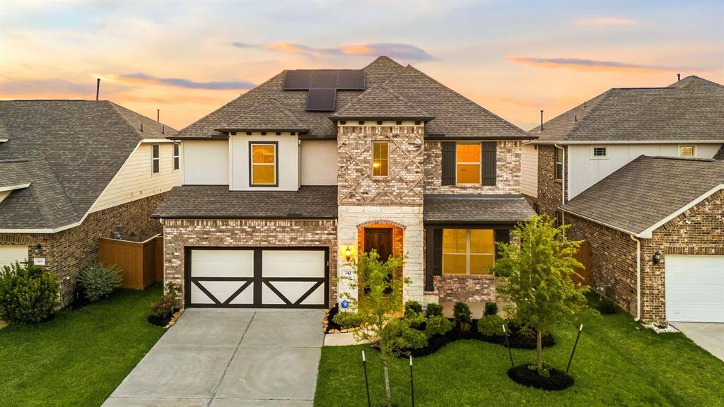 Welcome to your dream home nestled on a quiet, charming street in the heart of Sunterra. This beautifully crafted residence boasts exceptional curb appeal with a lush, manicured lawn, elegant landscaping, and a striking combination of stone, brick, and stucco. The inviting front porch, dark-stained front door, classic shutters, and graceful outdoor lanterns exude timeless charm, while the double-wide driveway offers both convenience and style. A picture-perfect blend of traditional elegance and modern comfo