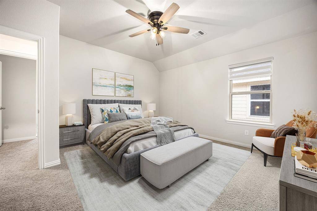 Secondary bedroom features plush carpet, raised ceilings, neutral paint, dark stained ceiling fan with lighting and a large window with privacy blinds.