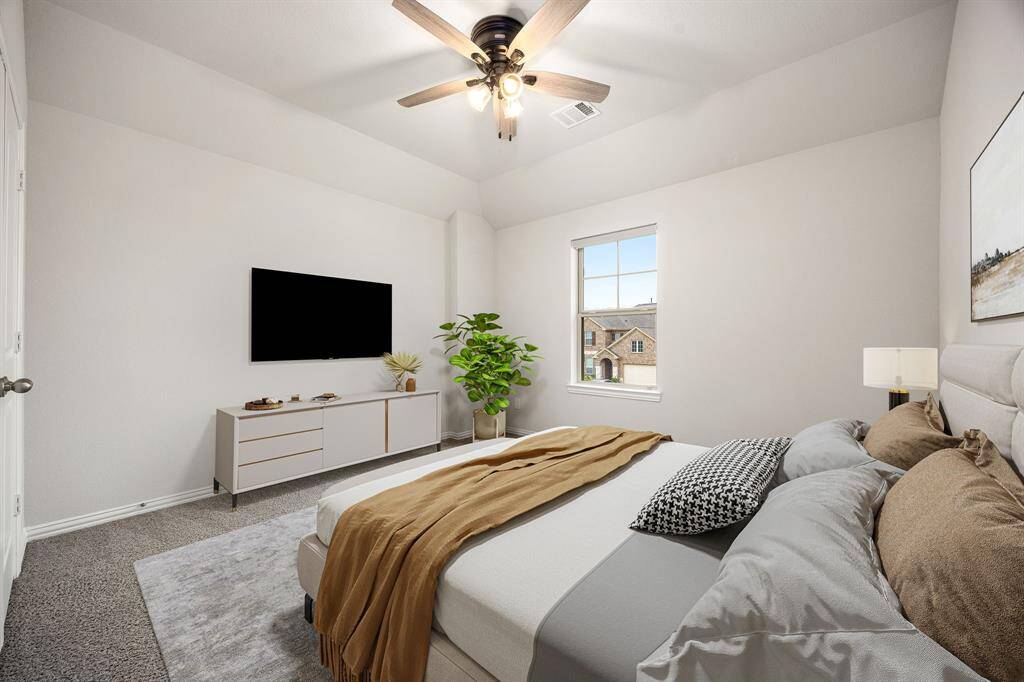 Secondary bedroom features plush carpet, raised ceilings, neutral paint, dark stained ceiling fan with lighting and a large window with privacy blinds.