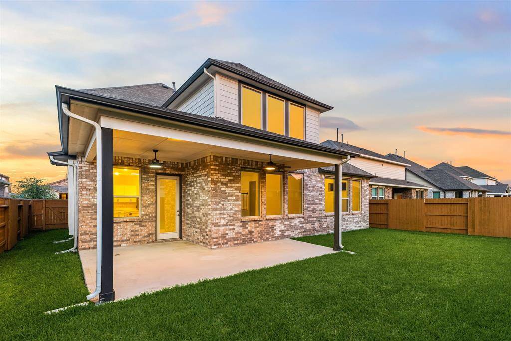 Enjoy outdoor living at its finest with this spacious covered patio and private, fully fenced backyard—perfect for relaxing evenings or weekend gatherings. The elegant brick exterior and upgraded lighting create a warm, inviting ambiance, while the lush green lawn offers plenty of space for play, pets, or future landscaping dreams.