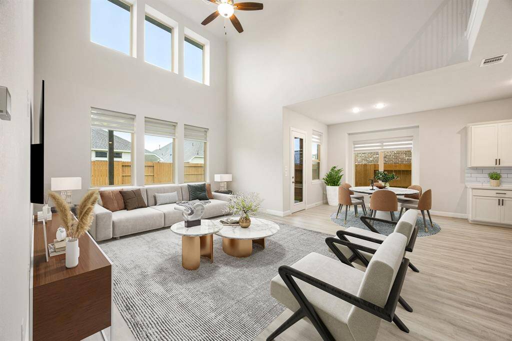 Welcome to a bright and airy living space designed for both comfort and connection. This generously sized room offers the ideal backdrop for hosting guests or enjoying a peaceful night in. Gleaming wood floors, towering ceilings, and oversized windows flood the room with natural light, creating an inviting ambiance. Modern recessed lighting enhances the warmth of the space, while the seamless flow into the beautifully appointed kitchen makes entertaining effortless and enjoyable.
