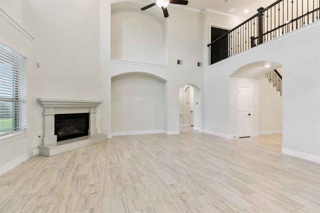 Living room has gas log fireplace, TV nook, with art niche above.