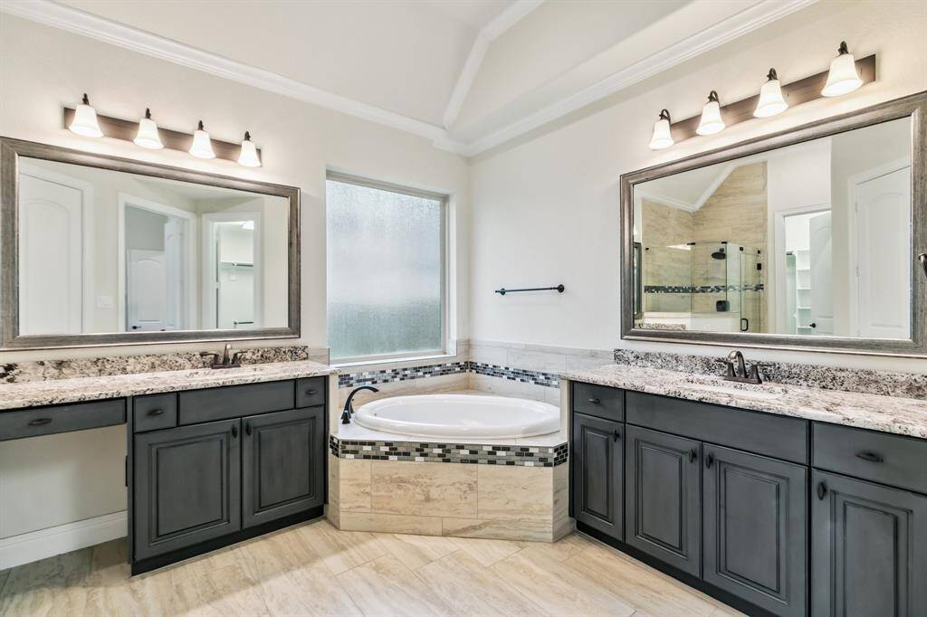 Primary bath has his and her vanities, and a soaking tub.