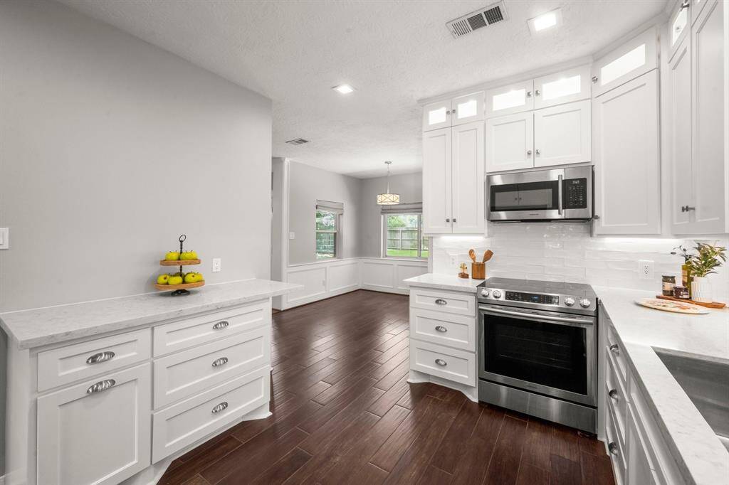 Breakfast room extends toward the back of the home, featuring beautiful windows that fill the space with natural light, complemented by custom window treatments that add a tailored, finished touch.