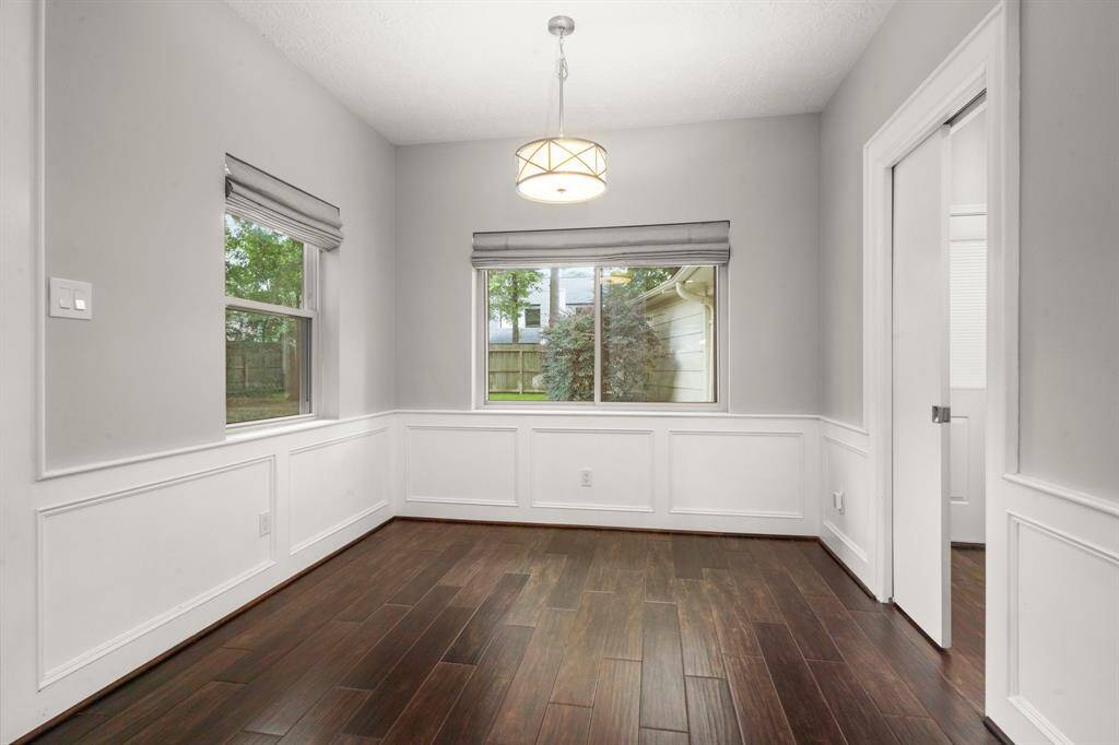 Breakfast room extends to the back of the home, showcasing beautiful windows with custom window treatments and a charming chandelier that adds warmth and character to the space.