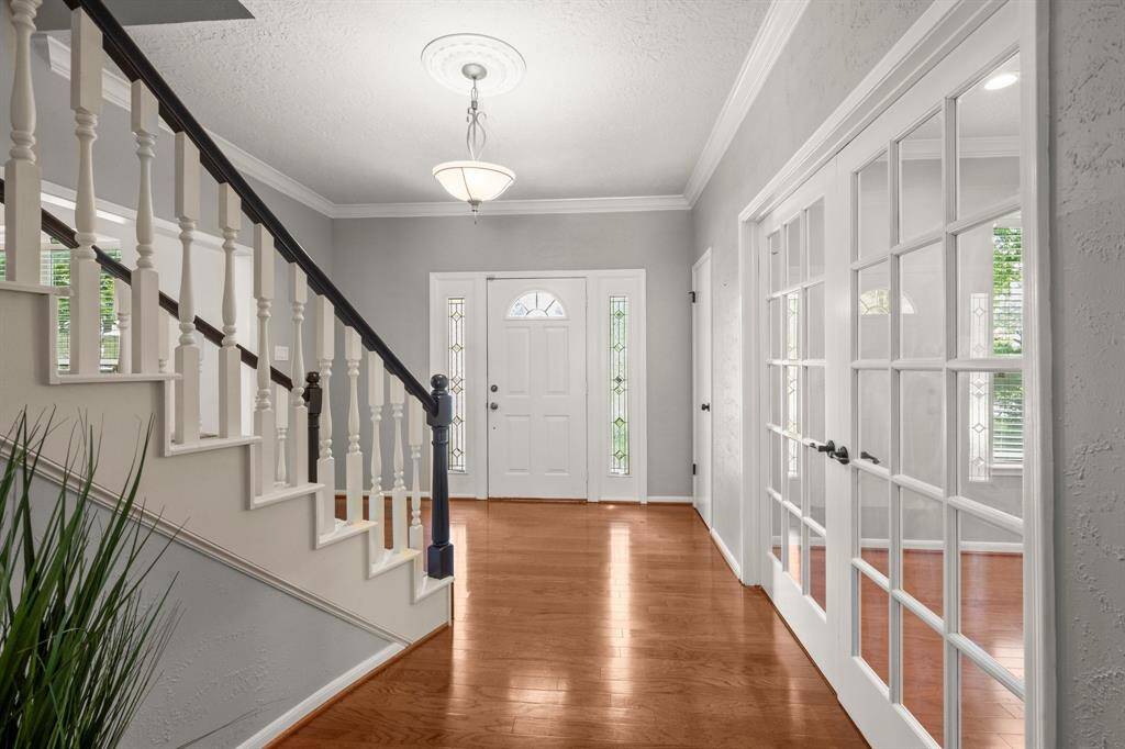 A neutral paint palette, detailed crown molding, and a lovely chandelier in the foyer create a timeless first impression.