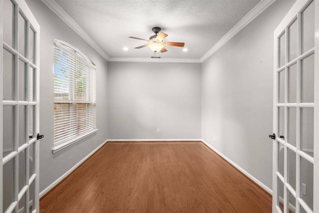 Home office is ideally situated at the front of the house for added privacy, with sun-filled windows that flood the space with natural light and offer serene views of the front lawn. Additional features include recessed lighting, a ceiling fan for comfort, and elegant French doors that enhance both style and function.
